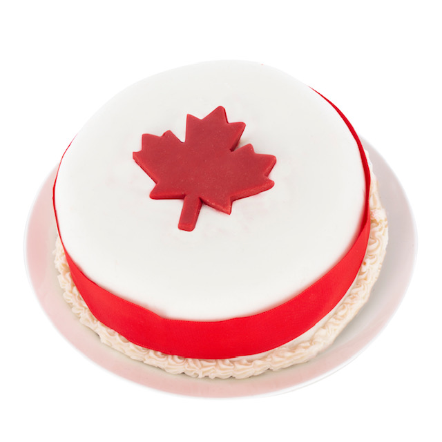 cake with white icing and a red Canadian leaf on it