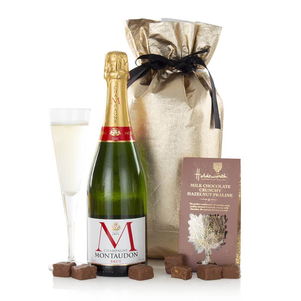 a bottle of champagne and chocolates presented in a gold gift bag
