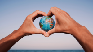 Two hands forming a heart, holding a globe