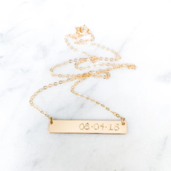 gold bar necklace with day, month, year stated in numerals