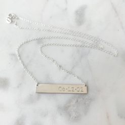 silver bar necklace with day, month, year stated in numerals