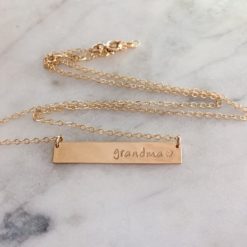 gold necklace with bar that states grandma