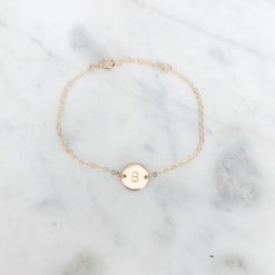 gold chain bracelet with monogram pendant in the middle