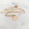 gold necklace with circle pendant that states mama