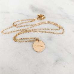 gold necklace with circle pendant that states mama