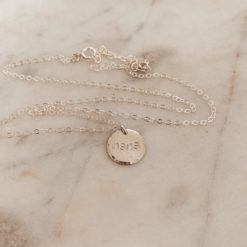 silver necklace with circle pendant that reads nana