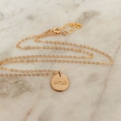 gold necklace with circle pendant that reads oma