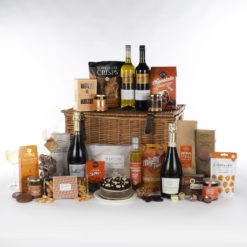 a grand gift basket with wine, champagne, cake, coffee, and a variety of other snacks and treats